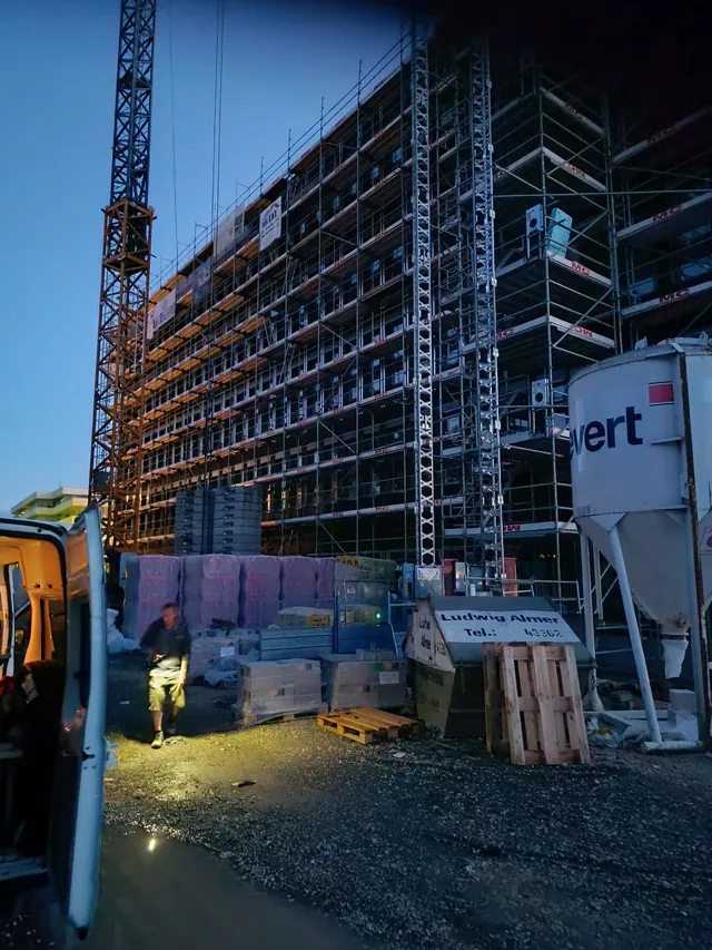 Gebäudeecke des Lillenthallcenters mit Gerüst und Baukran unter blauem Himmel