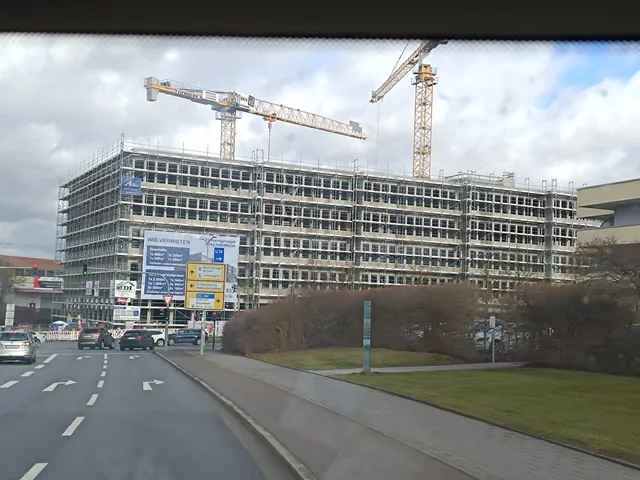 Straßenansicht des eingerüsteten Lillenthallcenters mit zwei Baukränen